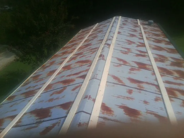 Rusted metal roof panels with new wood purlins before replacement — Storm Damage Roof Repair in Erick by Roofing Brothers