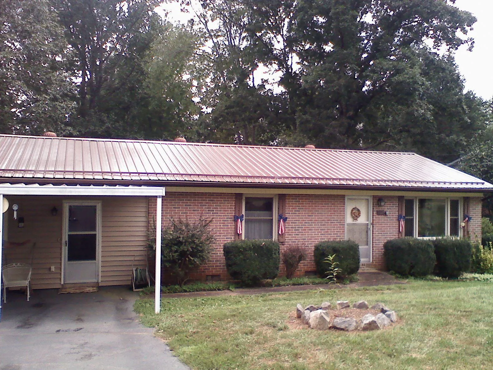 Bronze metal roof and carport on a brick ranch home — Roof Repair work by our crew in Erick