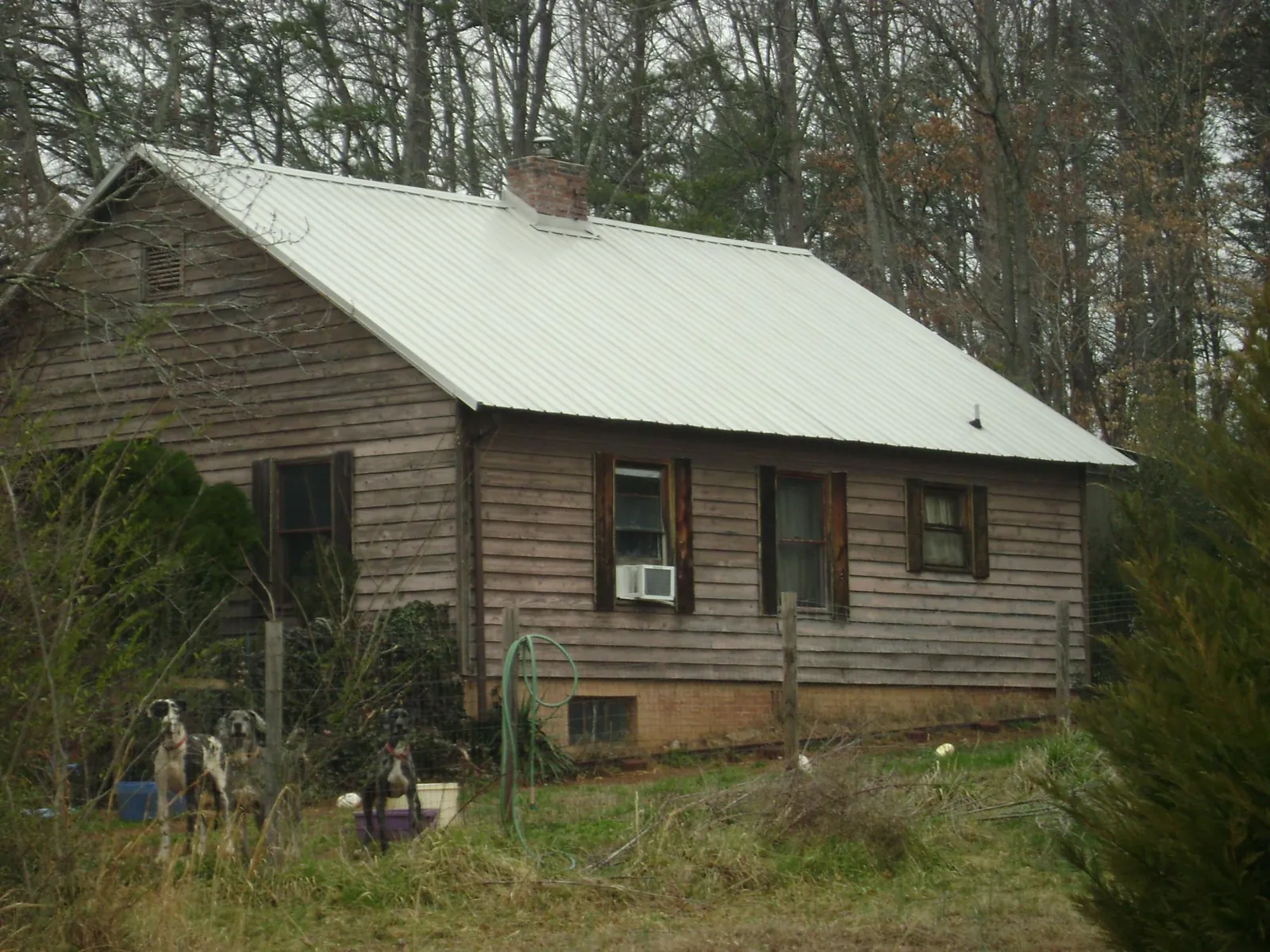 White metal roof on an old wood sided farmhouse, from a Metal Roof Installation job in Erick